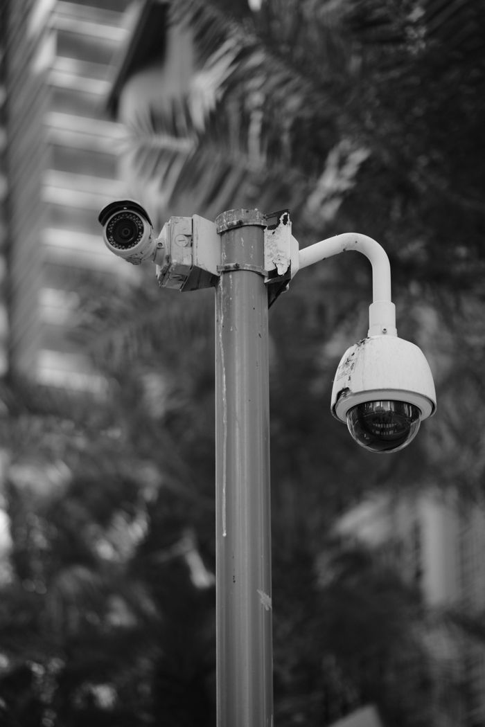 Black and white photo of security cameras on a pole in downtown Qatar.