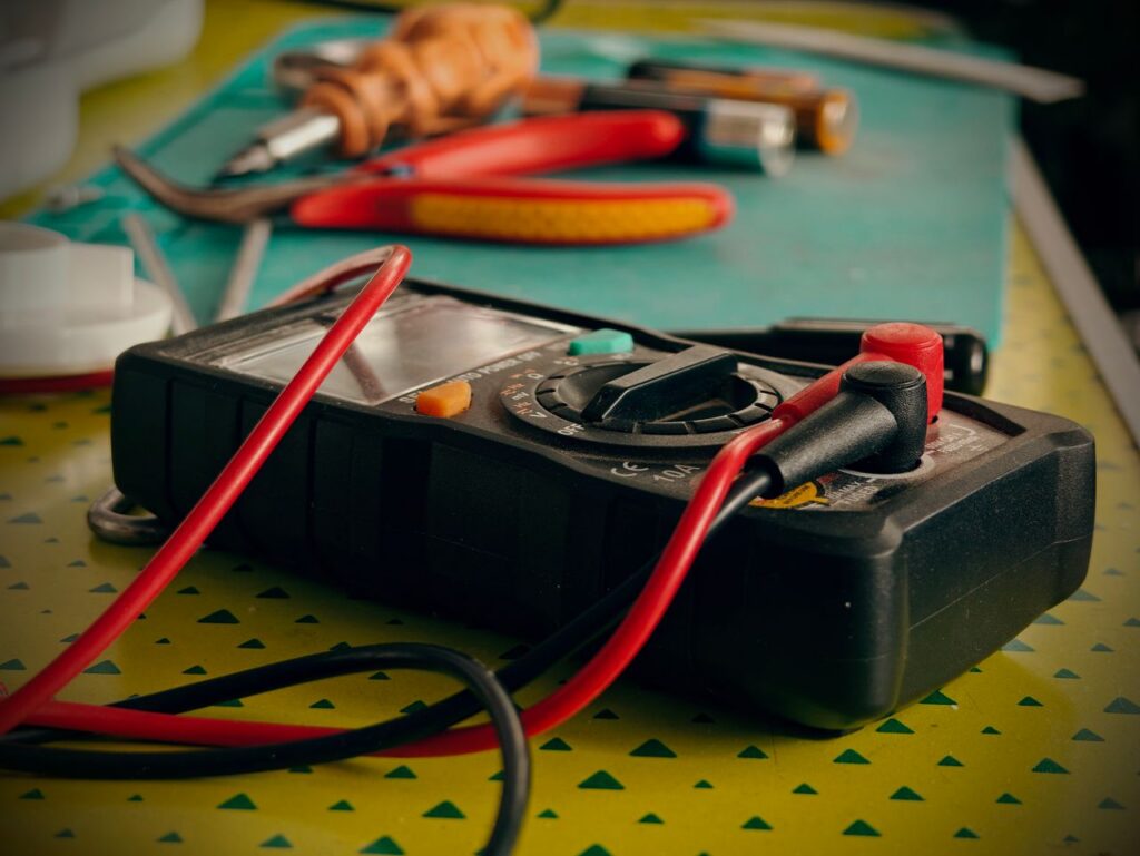 pexels photo 38292956 38292956 Close-up view of a multimeter and various tools on a workspace table.
